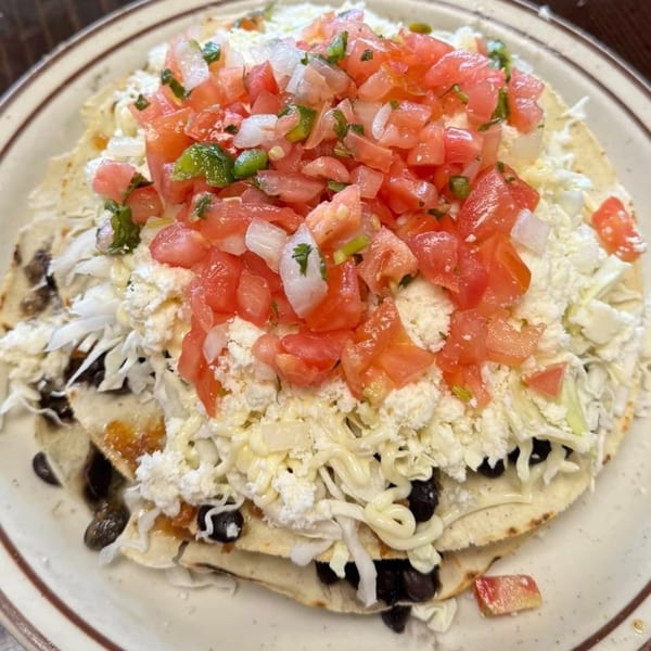 Mi Rinconcito's Mexican tostada with black beans, cheese, shredded cabbage, and pico de gallo.